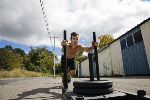 athletic-man-exercising-with-sled-outside-gym-royalty-free-image-1056425154-1551576538